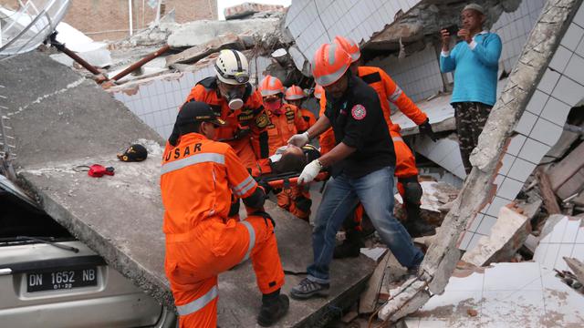Tim Penyelamat mengevakuasi korban (sumber liputan 6.com)